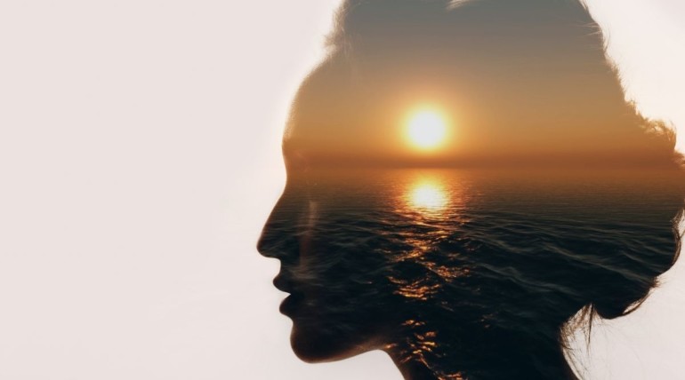 Picture of woman with a sunset imposed over her head