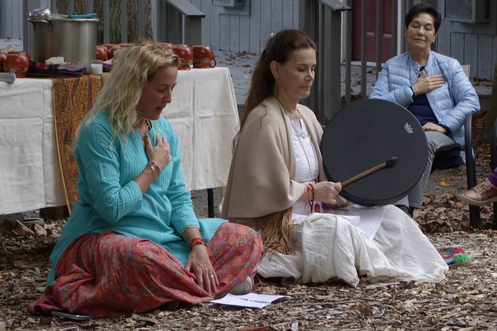 two-women-performing outdoor-drumming-ritual-as-part-of-spiritual-retreat